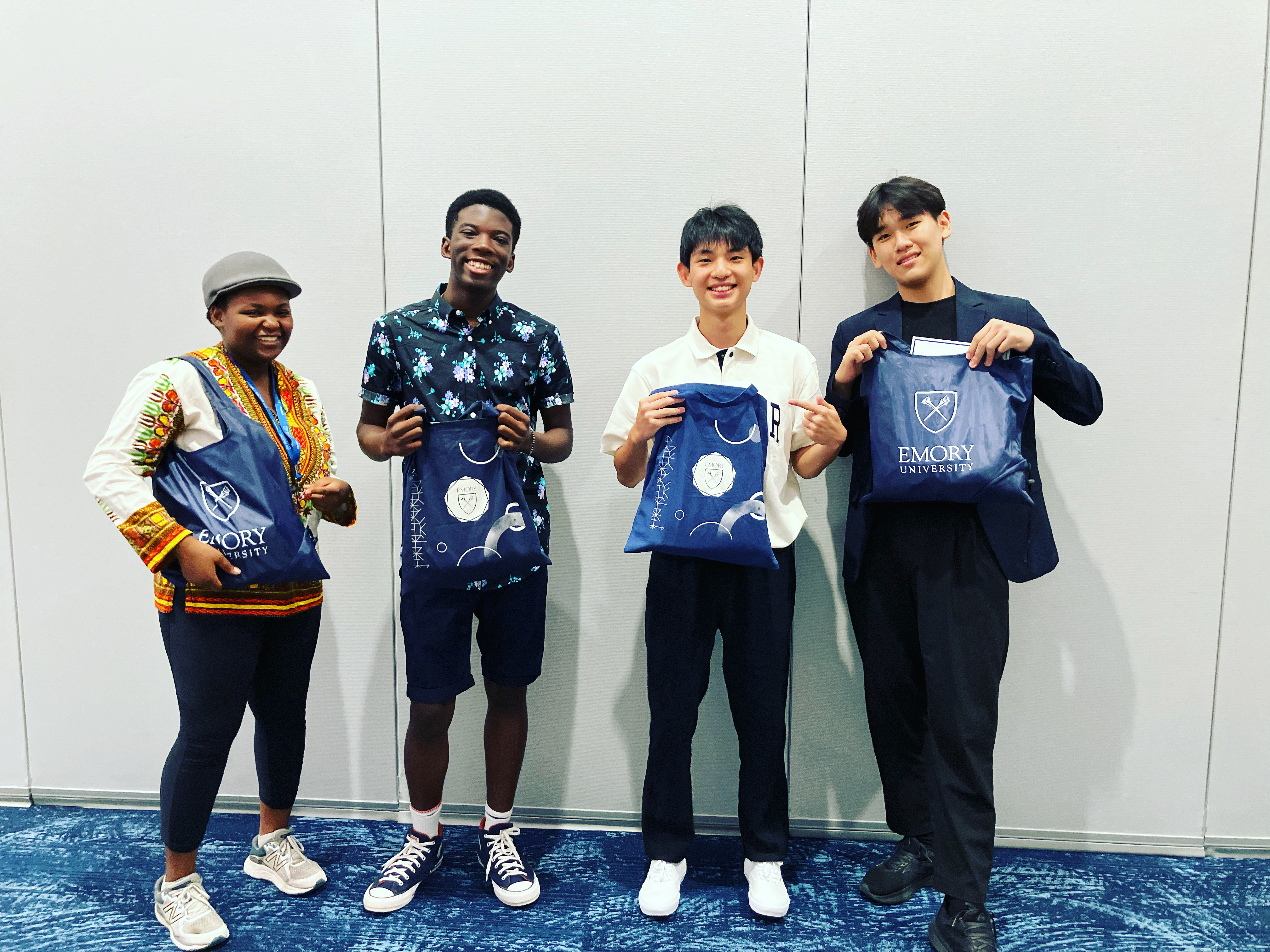 Four students holding merch swag bags